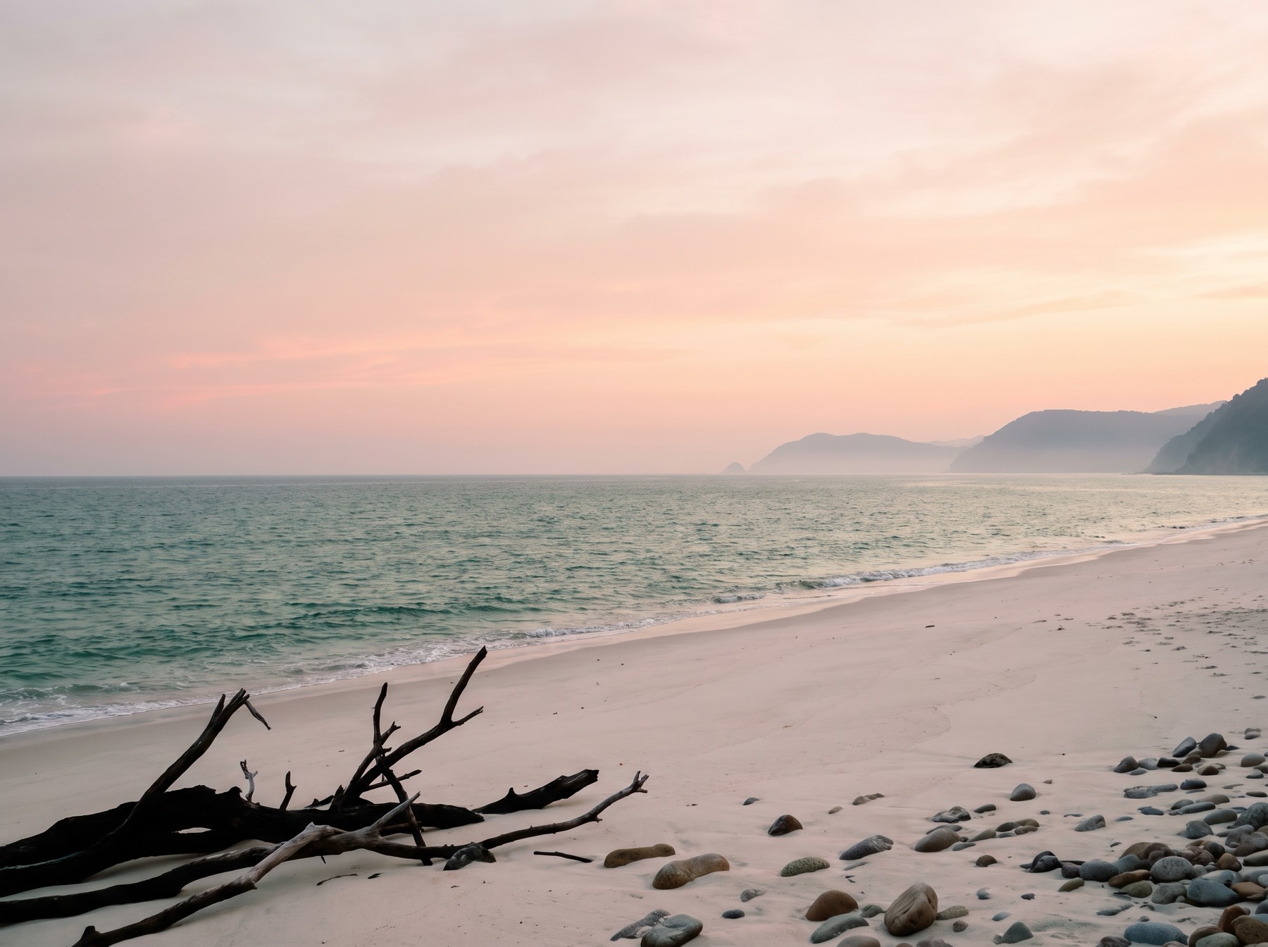 A quiet beach at dusk under a pink sky